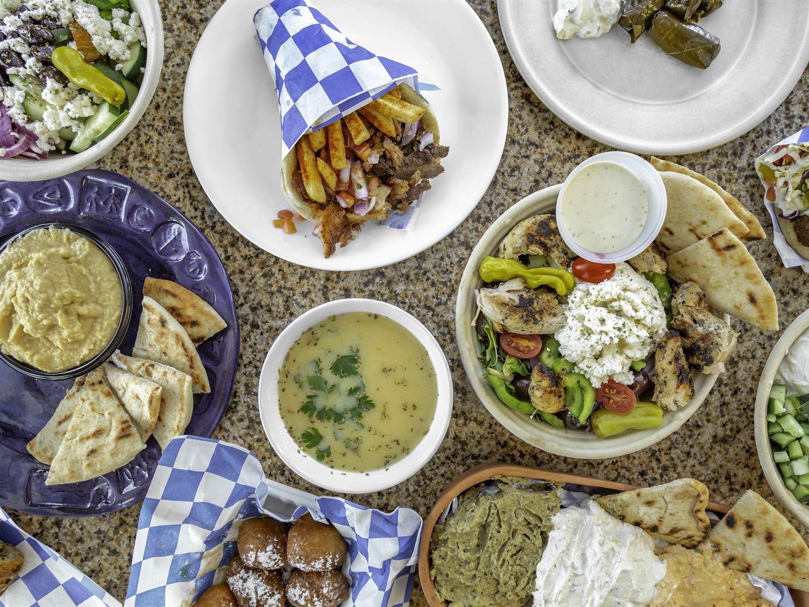 A spread of gyros, salads, spreads and sides from The Gyro Spot catering